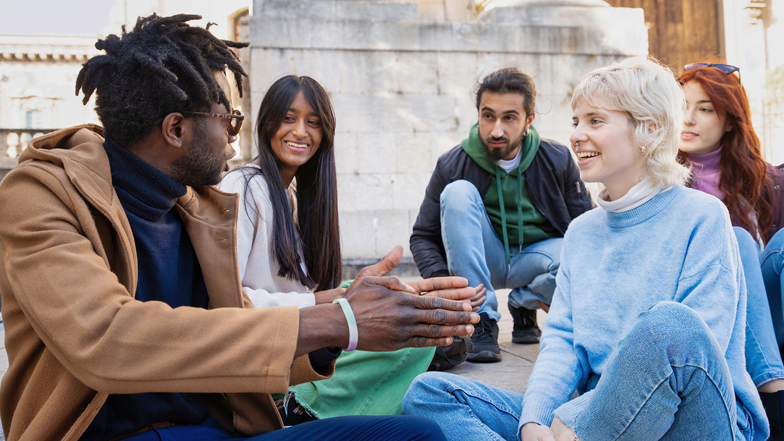 Five college students sit in a group during a discussion. 