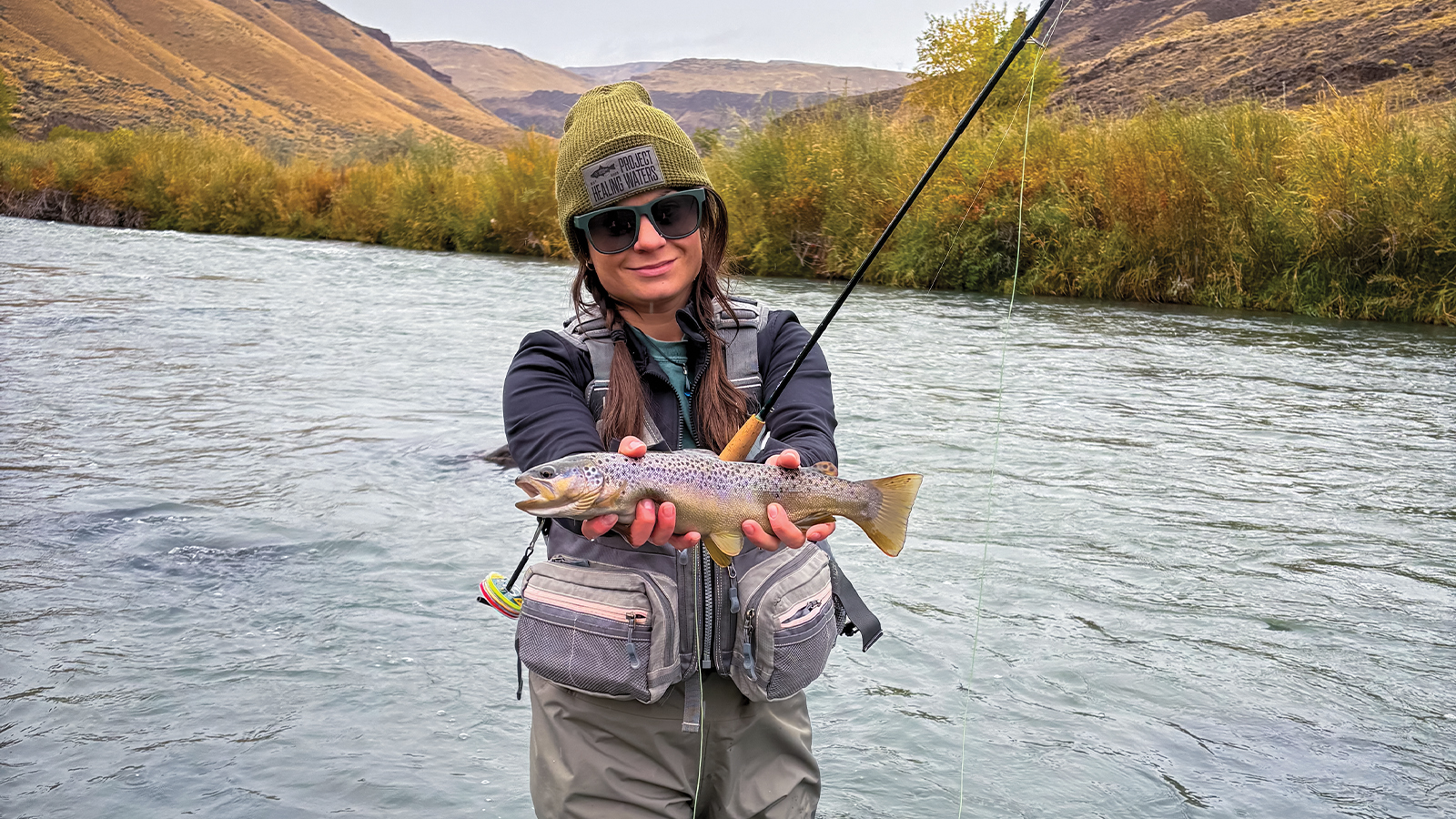 Shandy Simpson displays a fish she caught while fly fishing.