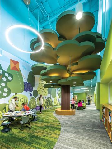 Colorful and interactive school built design with a tree hanging from ceiling. Photo Courtesy of DLR Group.