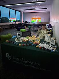 Doctor of Occupational Therapy student Kristi Baker, OTA, sits at welcome table in a sensory room. 