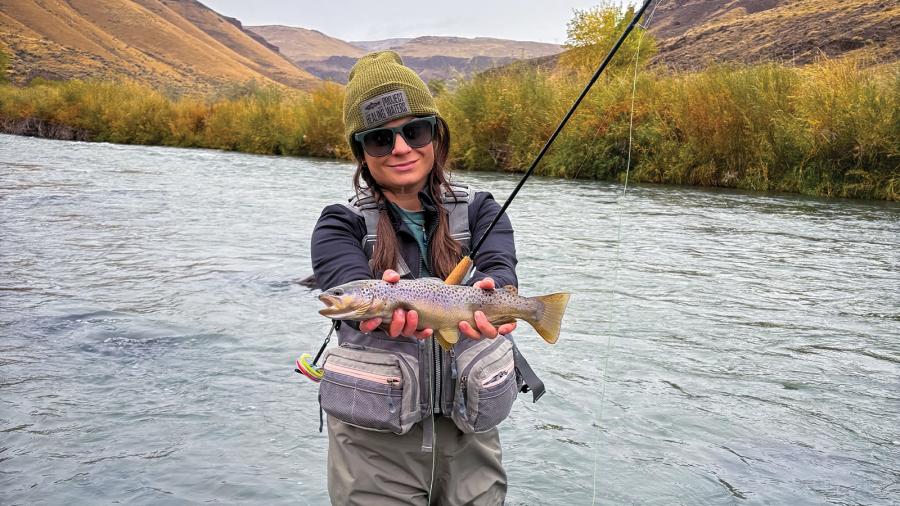 Shandy Simpson displays a fish she caught while fly fishing.